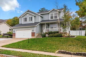 View of front of property with a porch, an attached garage, driveway, brick siding, and roof with shingles