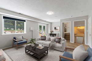 Virtually staged Living room featuring a textured ceiling, stairs, and wood finished floors