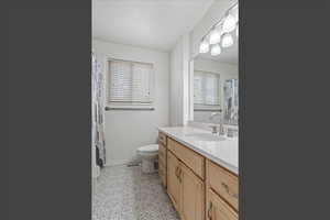 Bathroom with vanity, plenty of natural light, curtained shower, and light tile patterned floors
