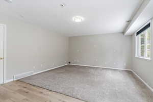 Unfurnished room with a textured ceiling and light wood-type flooring