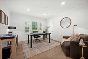 Office area featuring crown molding, light wood-style floors, and recessed lighting
