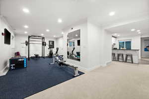 Workout room featuring recessed lighting, crown molding, and light colored carpet