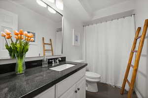 Bathroom with ornamental molding, dark wood-type flooring, vanity, and curtained shower
