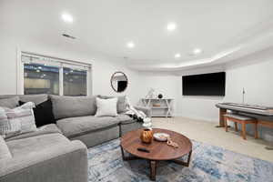 Carpeted living area featuring recessed lighting and ornamental molding