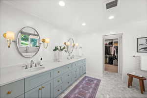 Full bathroom with double vanity, a spacious closet, ornamental molding, and recessed lighting