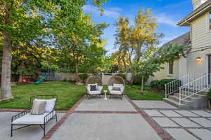 Fenced backyard featuring a playground and a patio