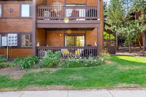 Doorway to property featuring a lawn