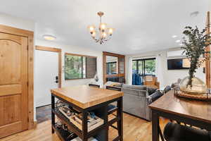 Dining room with a chandelier, light wood-style floors, and recessed lighting