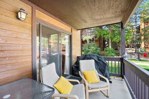 Covered porch featuring a grill