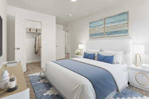 Carpeted bedroom with a walk in closet and baseboards