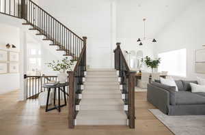 Stairway featuring a high ceiling and wood finished floors