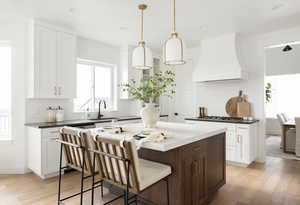 Kitchen featuring plenty of natural light, white cabinets, dark brown cabinets, a breakfast bar area, and recessed lighting