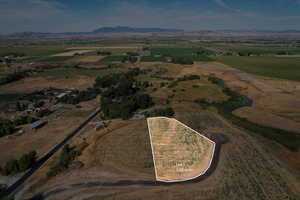 Aerial view of property and surrounding area with mountains, rural landscape, and property boundaries highlighted
