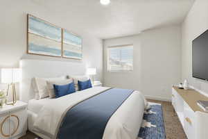 Bedroom featuring dark carpet and a textured ceiling