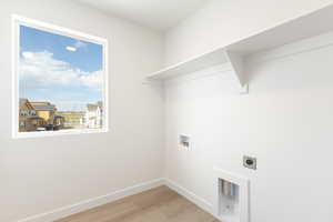 Laundry area with light wood finished floors, washer hookup, and electric dryer hookup