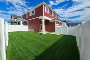 Back of property with a fenced backyard, a mountain view, and a gate