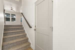 Stairway with recessed lighting, ceiling fan, and wood finished floors