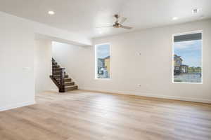 Empty room with stairway, light wood-type flooring, recessed lighting, and ceiling fan