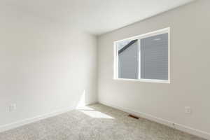 Empty room with carpet and baseboards