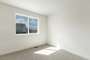 Carpeted spare room with baseboards