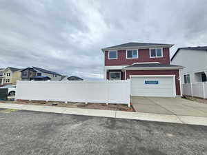 View of front facade featuring driveway, a garage, and a shingled roof