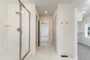 Full bathroom featuring a stall shower, light marble finish floors, and recessed lighting