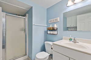 Bathroom with a shower stall, vanity, and a textured ceiling