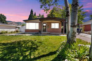 View of front facade with a front lawn and brick siding