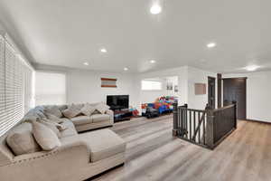 Living area with recessed lighting and light wood-style flooring