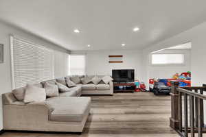 Living area with light wood-style flooring and recessed lighting