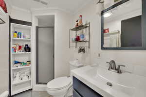 Bathroom with vanity, a shower stall, ornamental molding, and light tile patterned floors