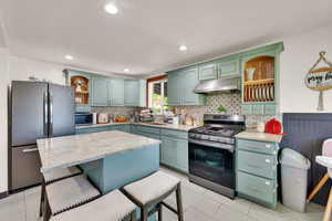 Kitchen featuring open shelves, stainless steel appliances, light stone countertops, under cabinet range hood, and recessed lighting