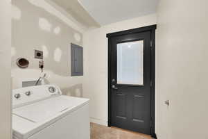 Washroom with washer / clothes dryer, electric panel, and light tile patterned floors
