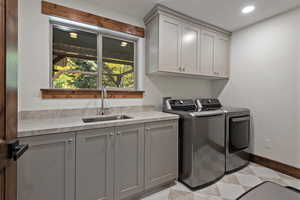 Laundry room with washer and clothes dryer, cabinet space, and recessed lighting