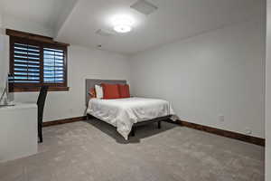 Bedroom featuring baseboards and light colored carpet