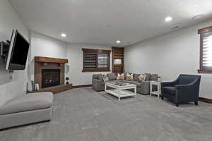 Carpeted living room with a tile fireplace and recessed lighting