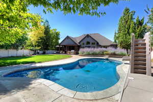 View of pool with a patio, a fenced backyard, a diving board, and stairs