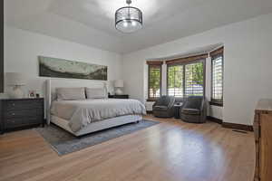 Bedroom featuring light wood-type flooring and a chandelier