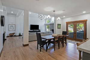 Dining area featuring recessed lighting, light wood finished floors, a fireplace, and french doors