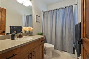 Bathroom featuring shower / bath combo with shower curtain, vanity, and light tile patterned flooring