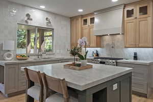Kitchen with gray cabinetry, tasteful backsplash, light wood finished floors, and recessed lighting