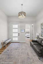 Living area with light wood-type flooring and a chandelier