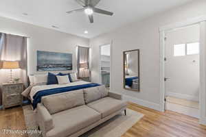 Bedroom featuring light wood finished floors, a spacious closet, a ceiling fan, and recessed lighting