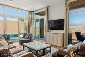 Living area with light wood-type flooring and a wall of windows