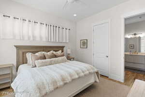 Bedroom featuring light wood finished floors, recessed lighting, ceiling fan, and ensuite bathroom
