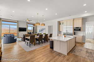 Kitchen with light brown cabinetry, open floor plan, healthy amount of natural light, a kitchen island with sink, and recessed lighting