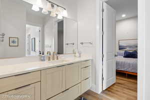 Bathroom featuring vanity, light wood-type flooring, and ensuite bath