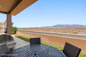 View of patio / terrace featuring outdoor dining space, grilling area, and a mountain view