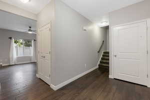 Hallway featuring stairs and dark wood-style floors