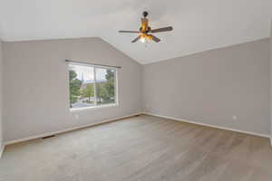 Unfurnished room with vaulted ceiling, light carpet, and ceiling fan